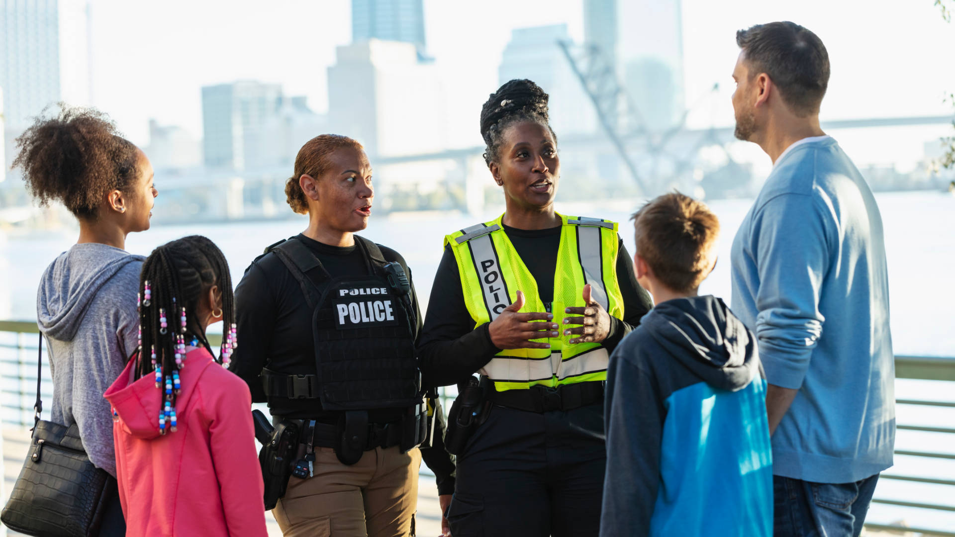 Peace officer speaking with a family overlooking a harbor